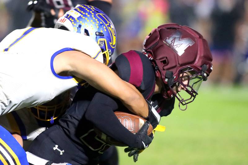 Marengo’s Hunter Muench is brought down by Johnsburg’s Mario Zakzrewski in varsity football at Rod Poppe Field on the campus of Marengo High School in Marengo on Friday, Oct. 3, 2025.