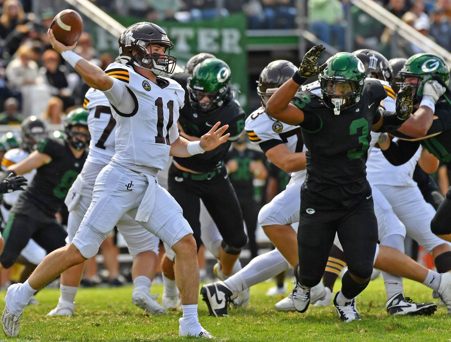 Joliet Catholic quarterback Lucas Simulick (11) fires a pass as Glenbard West’s Jayden Daniel (3) closes in during a game on September 6, 2025 at Glenbard West High School in Glen Ellyn.