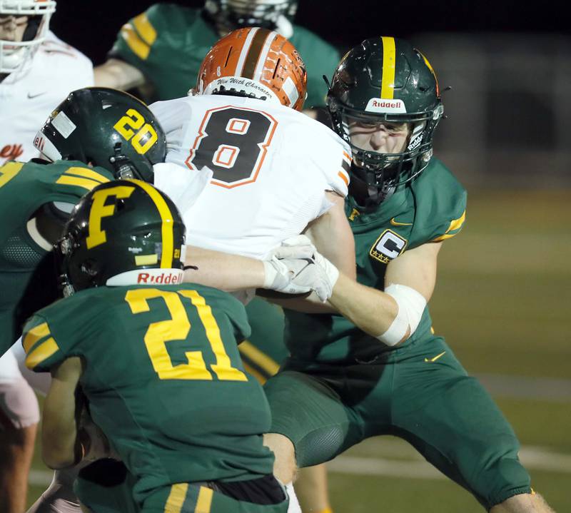 Fremd's Will Klimas (20) Jason Hardy (21) and Sam Tyska (3) wrap up Hersey's Carson Grove (8) Friday September 1, 2023 in Palatine.