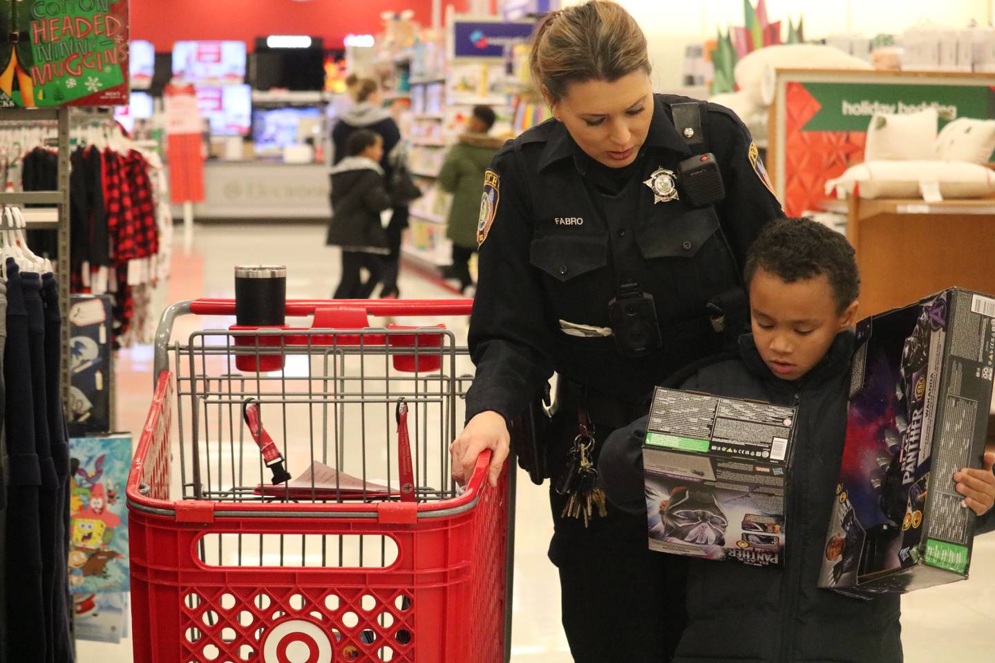 Officer Fabro (left) shops with Pierre Carter, 7, (right) of DeKalb as part of the "Heroes and Helpers" program put on by DeKalb police Sunday, Dec. 4, 2022.