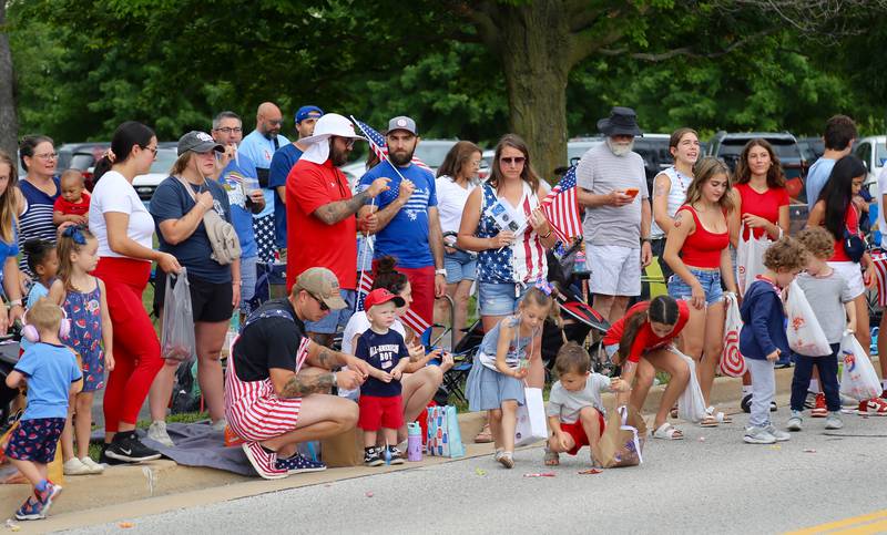 Kids collect candy that was tossed out during the Yorkville Independence Day Parade on Friday, July 4, 2025.