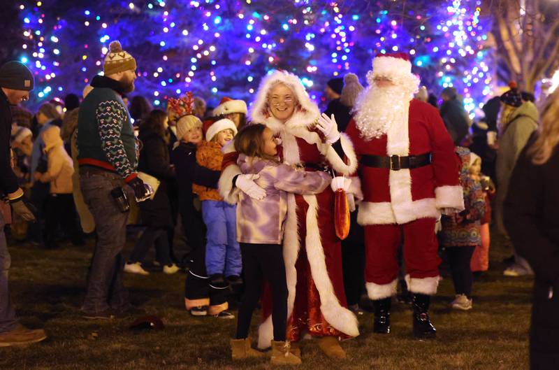 Mrs. Claus stops for a hug as she and Santa make their way to his house at the corner of West State and North Maple Streets Friday, Dec. 6, 2024, during the Sycamore Chamber of Commerce’s Walk With Santa in downtown Sycamore.