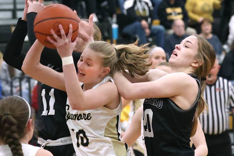 Sycamore's Lexi Carlsen grabs a rebound in front of Kaneland's Sam Kerry during the Class 3A regional final game Friday, Feb. 17, 2023, at Sycamore High School.