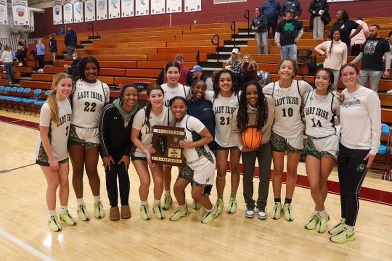 The Bishop McNamara girls basketball team celebrates with its IHSA Class 2A St. Joseph-Ogden Regional championship plaque after a 36-28 win over St. Joseph-Ogden in the championship game Thursday, Feb. 20, 2025.