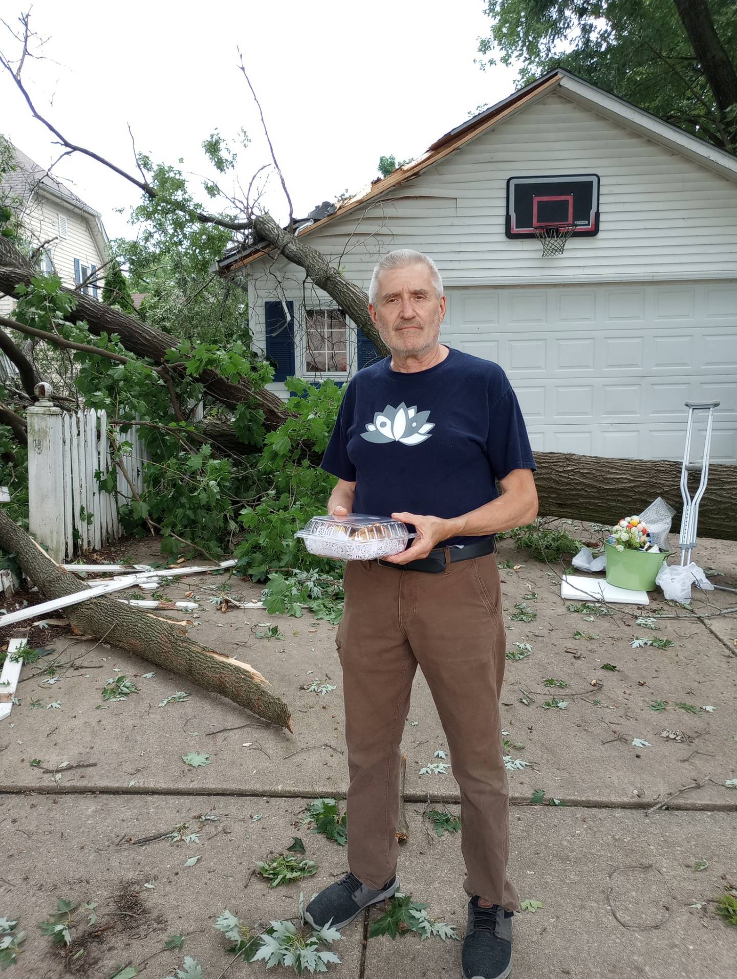 Mark Weaver, owner of Inglenook Pantry in Geneva, brought over a plate of cookies to his neighbor on Fourth Street, after a giant maple fell over on the driveway and part of the garage during the severe storms Sunday, July 14.