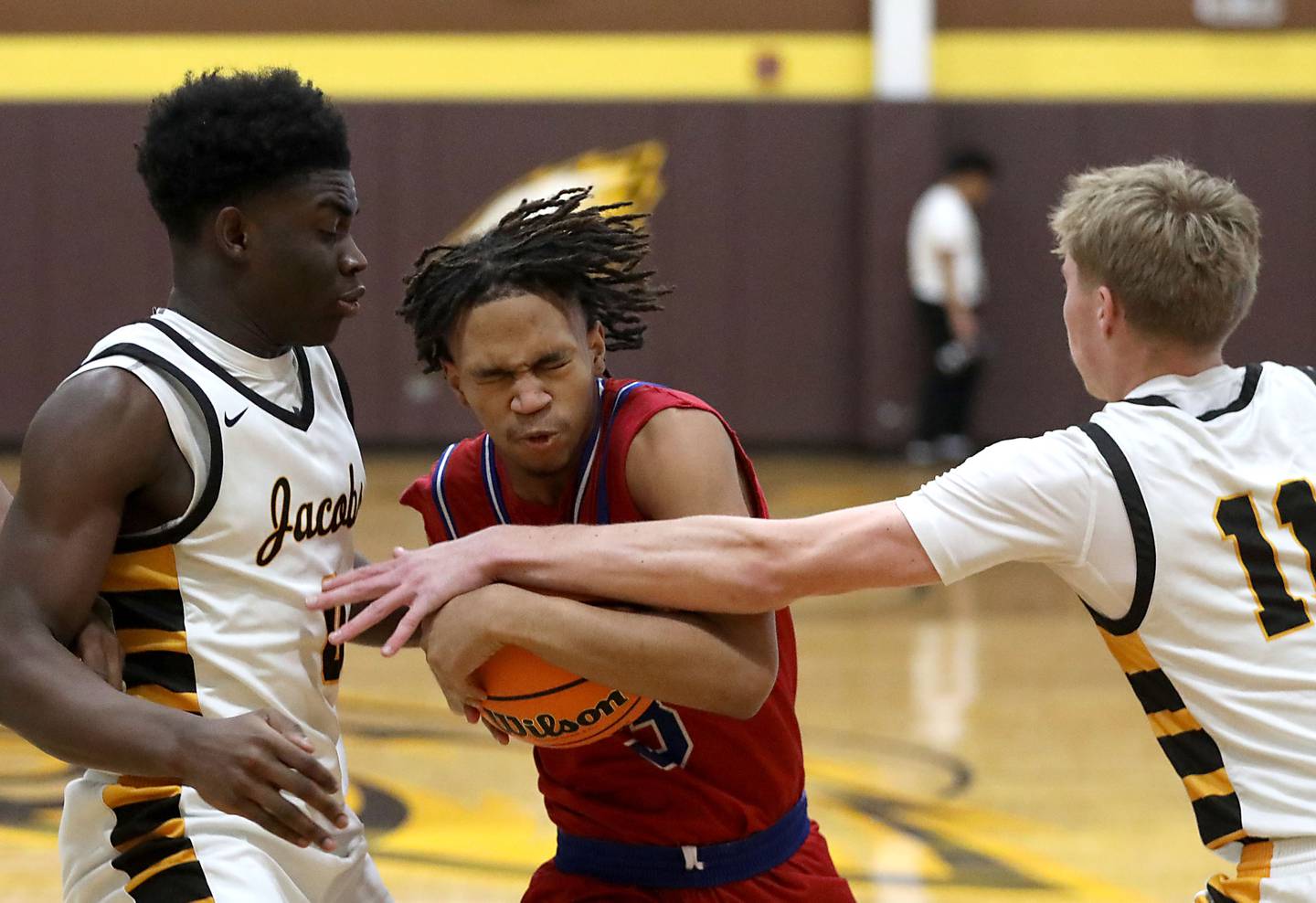 Dundee-Crown's Rasheed Trice tries to drive between Jacobs' Samson Averehi (left) and Carson Goehring (right) during a Fox Valley Conference boys basketball game on Tuesday, February. 3, 2026, at Jacobs High School in Algonquin.