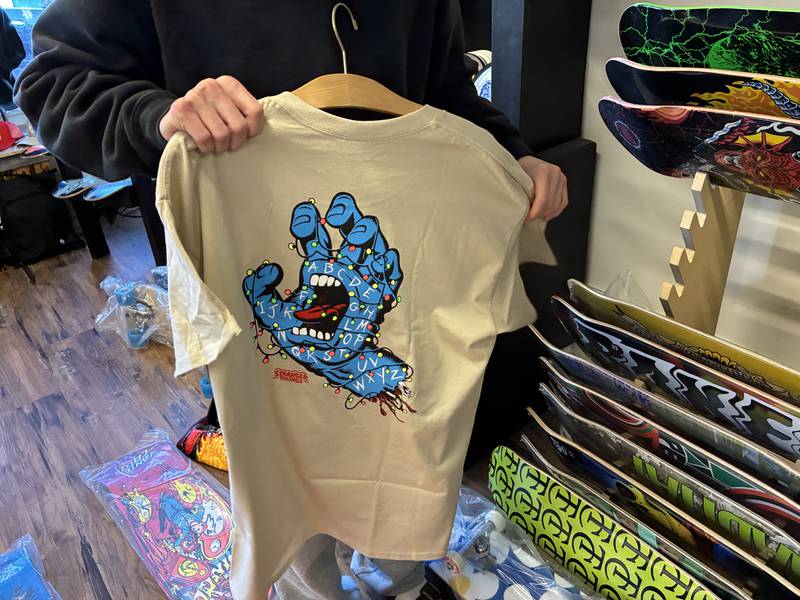 Finnley Chrisman sorts through the "Stranger Things" shirts on Sunday, Nov. 16, 2025, at The Trend Cellar in McHenry. The shop will start to sell its tie-in merchandise on Wednesday.