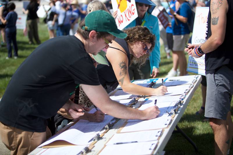 People sign candidates' nominating petitions at a rally on Labor Day, Sept. 1, 2025, for "Workers over Billionaires" along Route 64 in St. Charles.