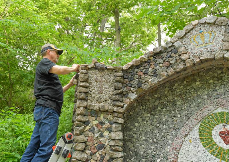 Volunteer Tom Van Arkel works on restoring some of the stone work on the Geneva Grotto, that was built by a priest in the 1930s, on Thursday, June 15, 2023.