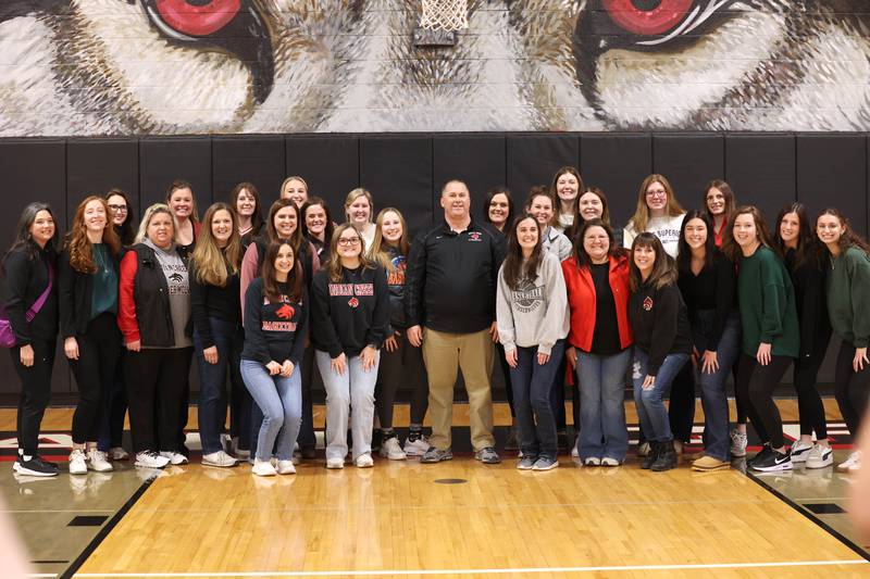 Indian Creek girls basketball head coach Paul Muchmore some of his former players Tuesday, Feb. 10, 2026, after being honored during a cermony held before Indian Creek took on Rosary. Muchmore, the longtime coach of the Timberwolves, was being celebrated at his last home game before retirement from coaching at the end of the season.