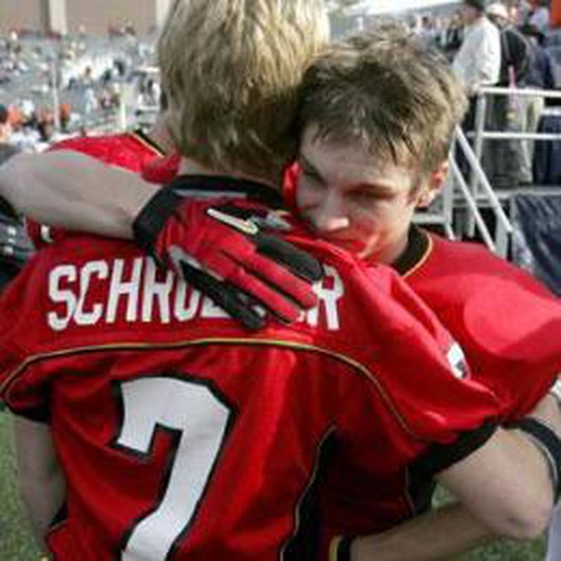 Batavia wide receiver Alex Warner hugs injured starting quarterback Alex Schroeder (7) after Batavia's loss to Normal Community during the Class 6A State Championship at Memorial Stadium at the University of Illinois in Champaign on Saturday. (Justin Runquist photo)