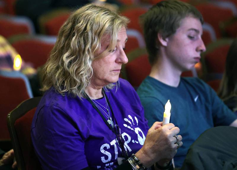 Lisa Casner, Safe Passage adult domestic violence counselor, holds her candle during a moment of reflection Monday, Oct. 7, 2024, during the annual Safe Passage Domestic Violence Candlelight Vigil and Survivor Speak-Out inside the Egyptian Theatre in downtown DeKalb.