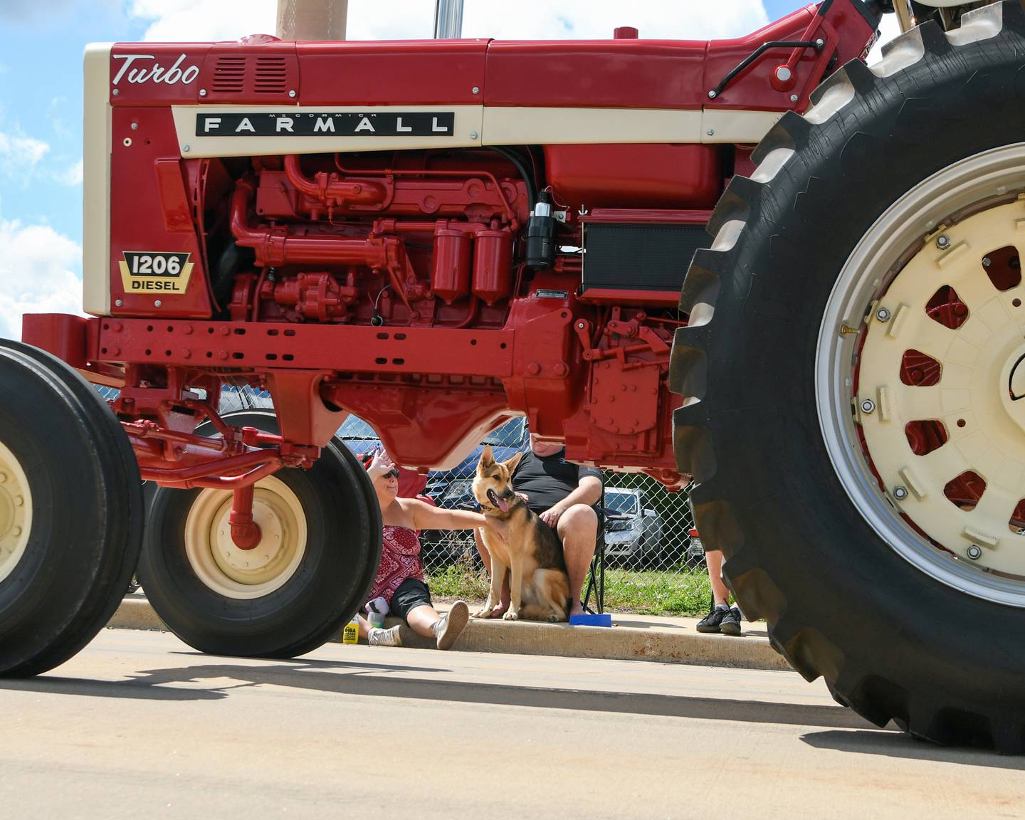 Jen Gavin waves and pets her German Shephard Taz, 1, along with her husband Gerry Gavin watch the Freedom Parade along the parade route in Sandwich on Saturday July 6, 2024.
