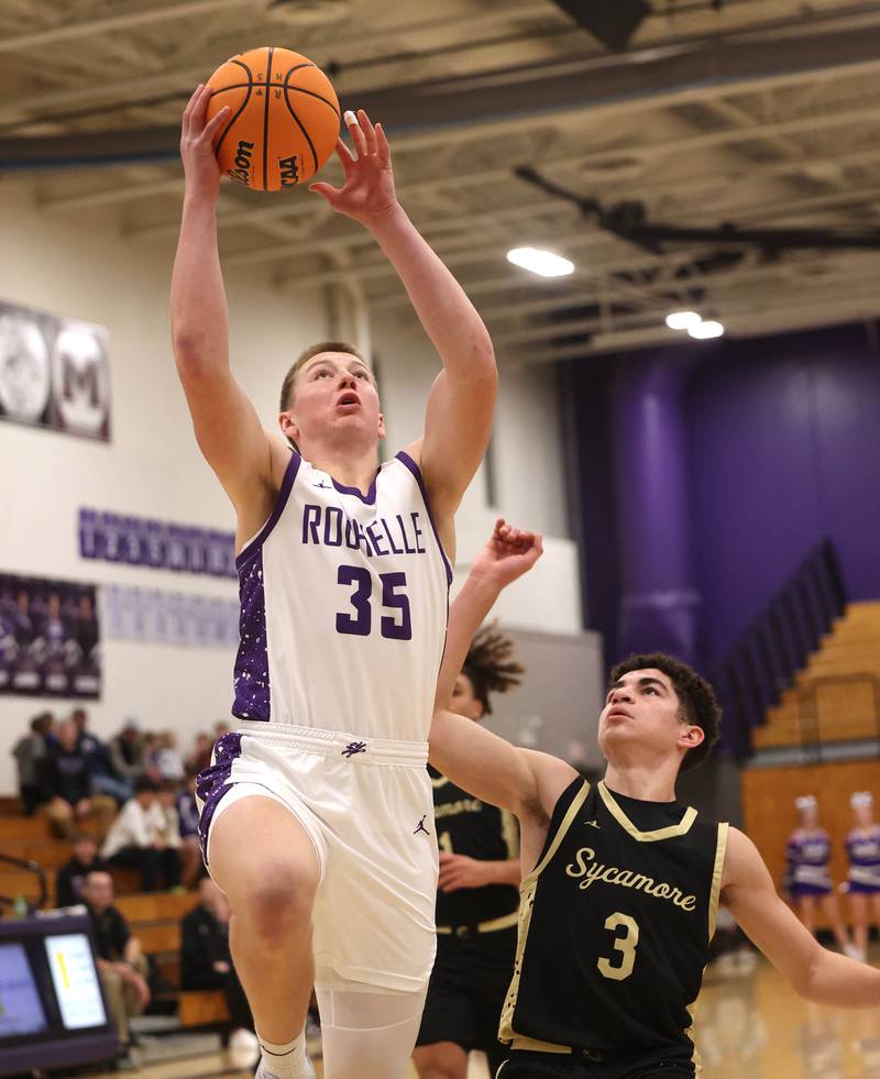 Rochelle's Eli Schweitzer shoots a layup in front of Sycamore's Marcus Johnson Friday, Dec. 5, 2025, during their game at Rochelle High School.