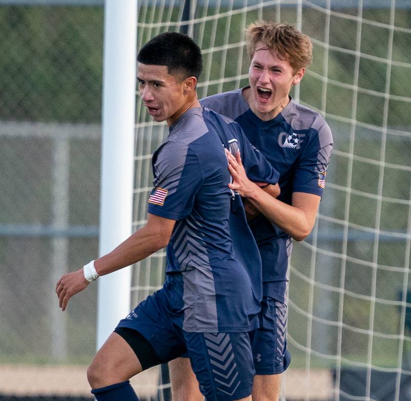 Oswego East's Israel Torres (left) celebrates with Austin Ward (7) after scoring a goal against Oswego during a soccer match at Oswego East High School on Monday, Sep 26, 2022.