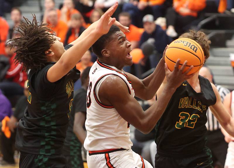 DeKalb's Davon Grant goes to the basket between two Waubonsie Valley defenders during their game Friday, Feb. 21, 2025, at DeKalb High School.