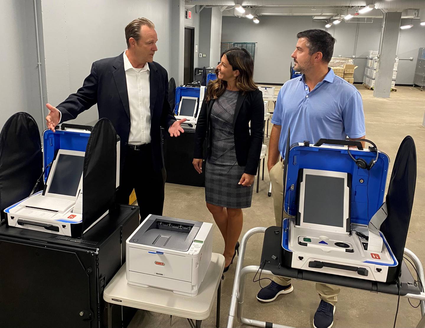 Will County Clerk Lauren Staley Ferry discusses recently purchased voting equipment and the modernization of local elections with Lawrence Leach, director of sales for Hart InterCivic (left) and Drew Kendall, executive vice president of Governmental Business Systems (right).