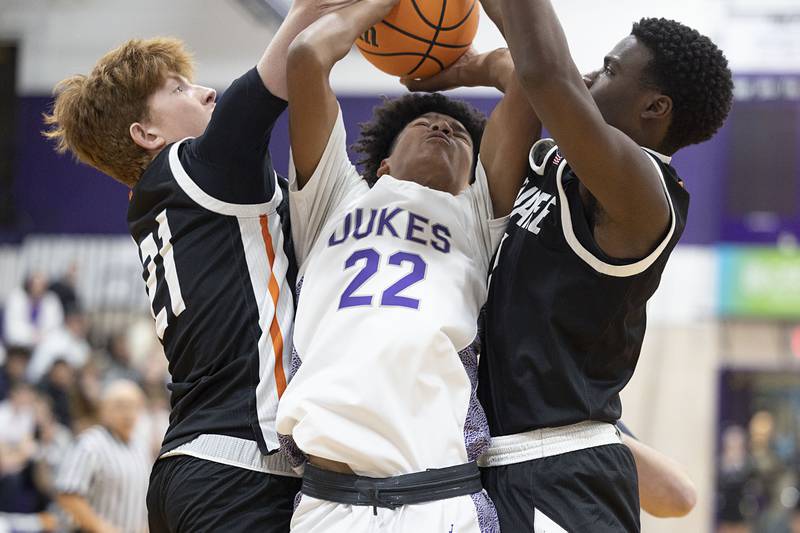 Dixon’s Xavion Jones is fouled by Kewanee’s Leeam Slover and Dayvon Robinson Tuesday, Dec. 2, 2025.