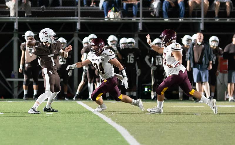 Montini’s Brandon Liston (34) and Cameron Richardson (60) rush Mount Carmel's Justin Lynch (1) in Chicago Sept. 13.