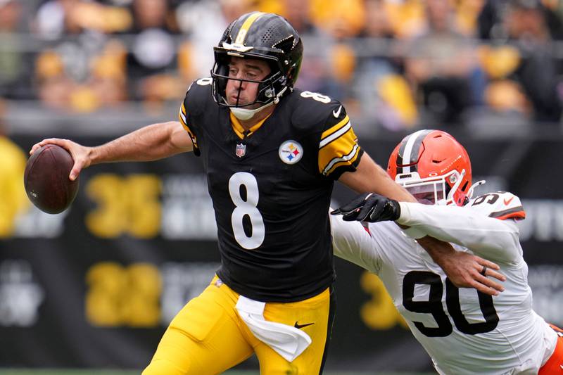 Pittsburgh Steelers quarterback Aaron Rodger (8) runs out of bounds with Cleveland Browns defensive end Joe Tryon-Shoyinka (90) defending during an NFL football game in Pittsburgh Sunday, Oct. 12, 2025. (AP Photo/Gene J. Puskar)