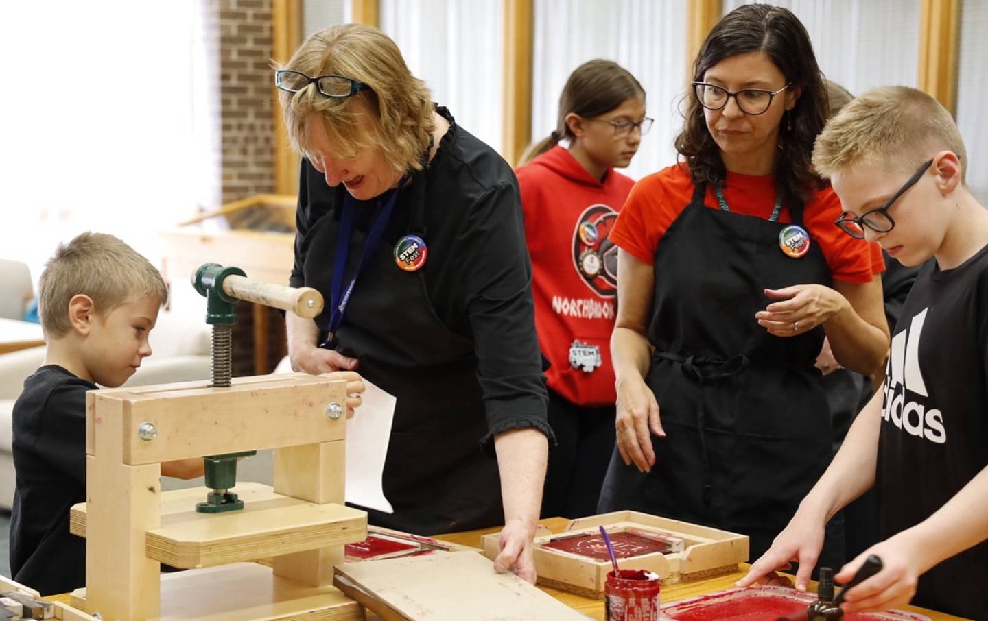 STEM Fest visitors use the BookBeetle printing press to make their own prints.