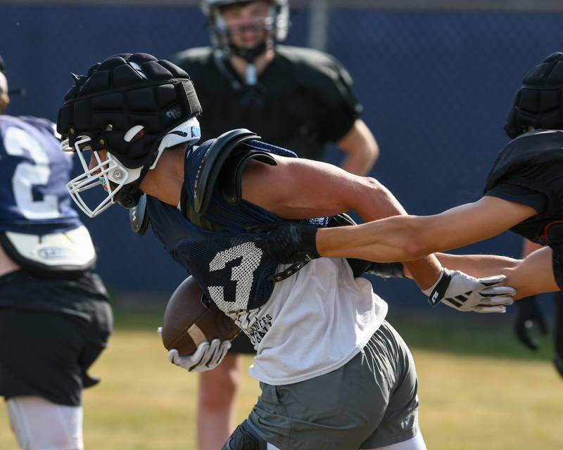 Teddy Manikas of Oswego catches the ball and tries to escape the tackle of a Kaneland defender during a joint practice School on Thursday July 10, 2025, held at Oswego High School.