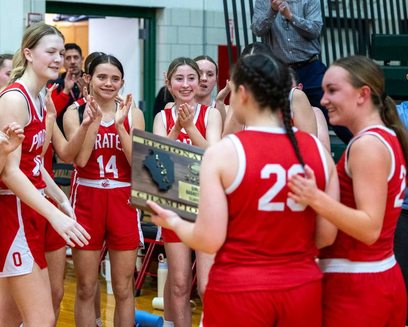 Ottawa's Girls Basketball team celebrates as teammate Mary Stisser (23) walks back to huddle with Regional Championship plaque after Regional Championship Win over Sterling on Thursday, Feb. 19, 2026 in Sellett Gymnasium at L-P High School.