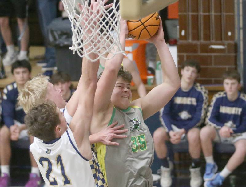 Seneca's Zeb Maxwell drives to the hoop as Marquette's Luke McCullough and Griffin Dobberstein defend on Friday, Feb. 21, 2025 in Bader Gym at Marquette Academy.
