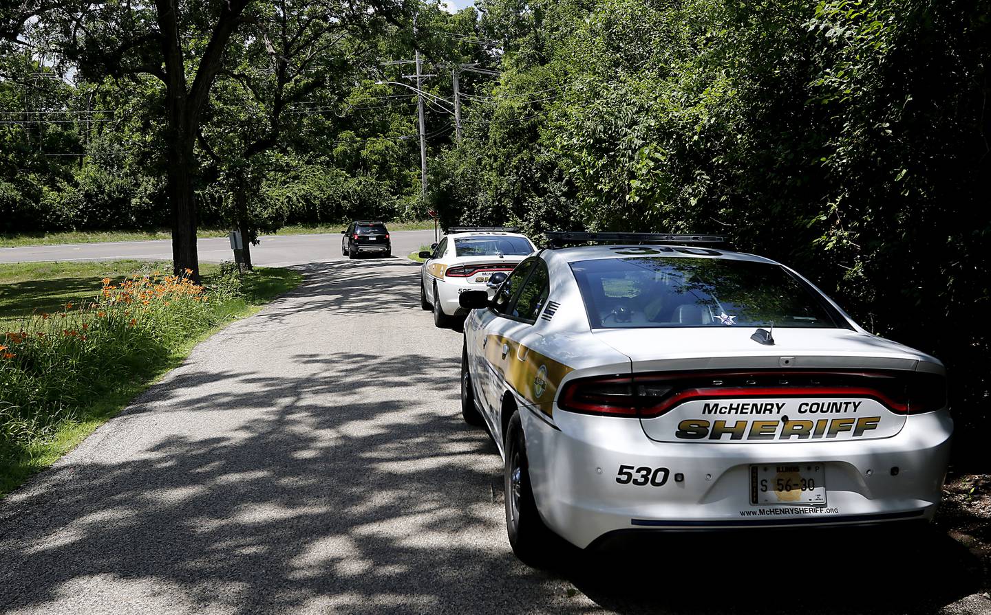 McHenry County Sheriff cars parked near the location of where a 15-year-old boy was fatally hit by a car the night before. Police said the driver fled the scene.