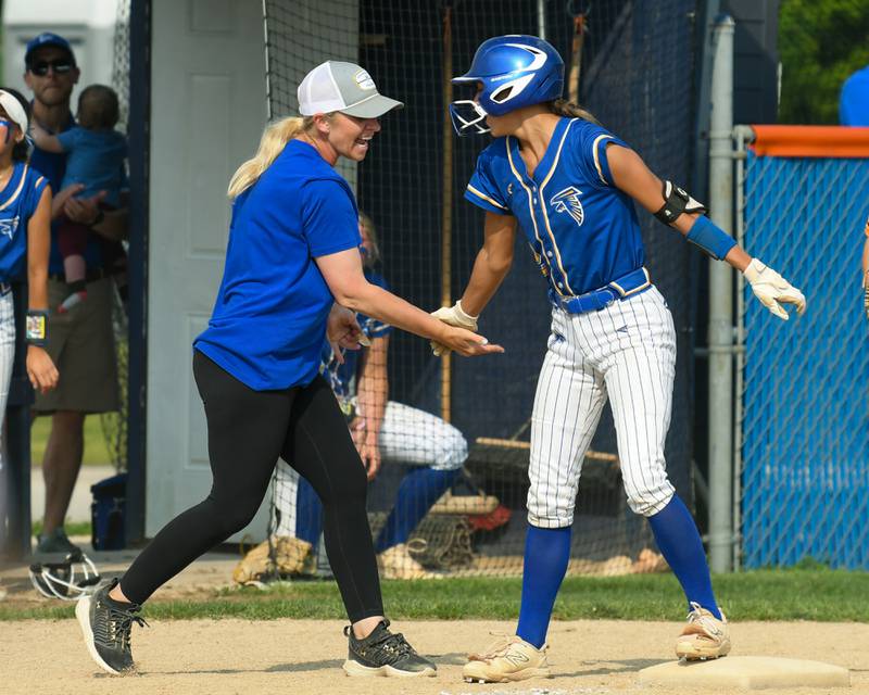 Wheaton North's Abby Del Preto (12) gets congratulated by her coach after hitting a triple during the sectional semifinal game against Weaton Warrenville South on Thursday June 5, 2025, held at Oswego High School.