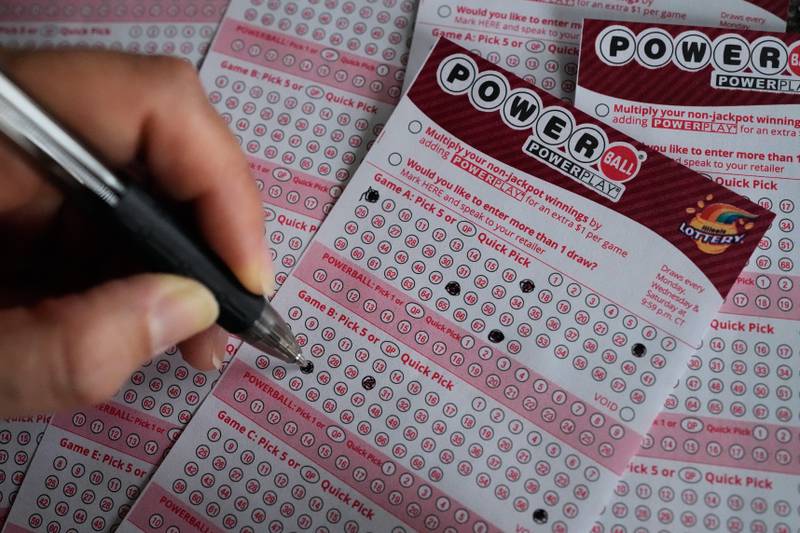 A customer fills out a Powerball lottery ticket at a convenience store in Mundelein, Ill., Monday, Dec. 15, 2025. (AP Photo/Nam Y. Huh)