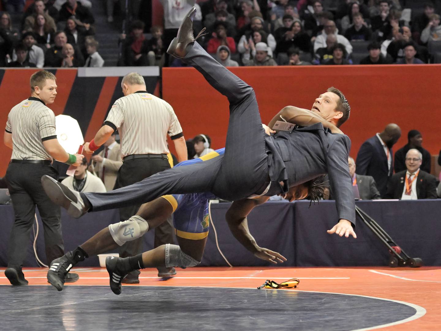 Charles Walker of Joliet Central throws his coach, Patrick McGovern in celebration of his win against LoyolaÕs Kai Calcutt in the Class 3A 215-pound final at the IHSA boys state wrestling championships at the State Farm Center in Champaign on Saturday, Feb. 22, 2025.