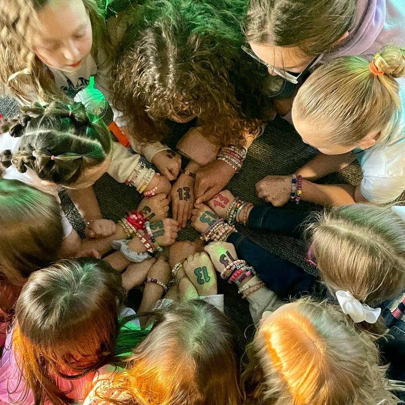 Friendship bracelets and the number 13, which is actually a sign of luck for Taylor Swift fans, are displayed by attendees of the Taylor Swift Night Night on Friday, April 5, 2024, at the Peru Public Library.