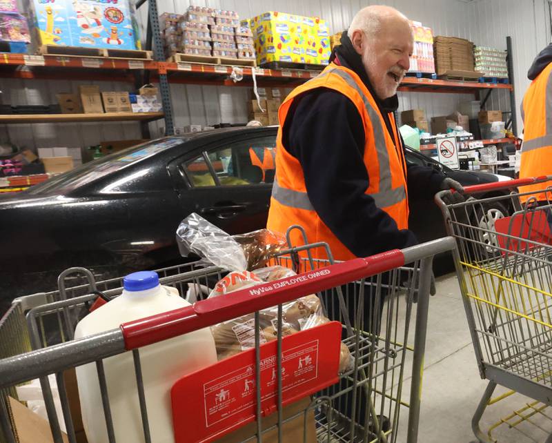 Fr. Ronald Margherio, of St. Bede Academy, pushes carts while volunteering during the annual Easter distribution on Wednesday, April 1, 2026 at the Hall Township Food Pantry in Spring Valley.