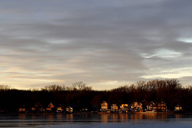 A band of sunlight lights up homes on Wednesday, Jan. 8, 2025, on Crystal Lake’s north side near Crystal Lake’s Main Beach.