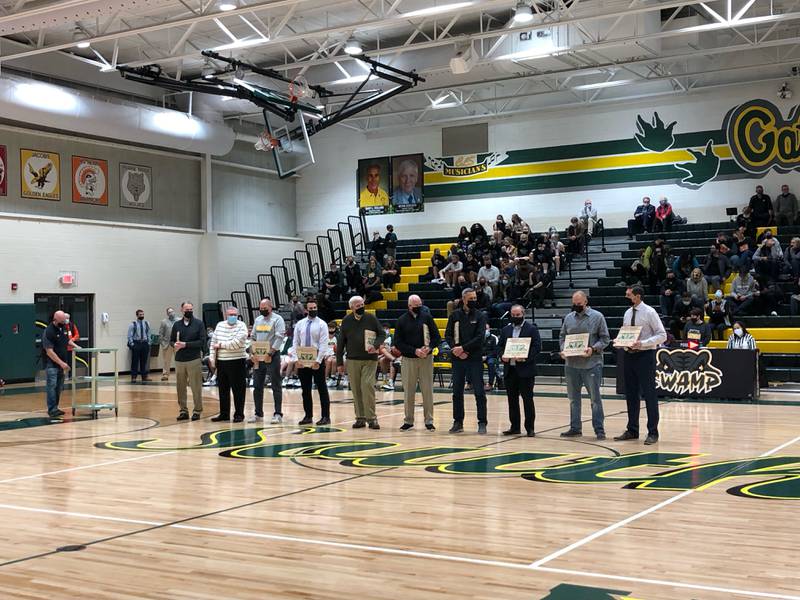 Crystal Lake South honored its girls and boys basketball coaches through the years last week. South athletic director Jason Bott is at the left, introducing the coaches. From left are girls coaches Jim Goodwin (representing his late father Ed Goodwin), Bill Butkus, Kyle McCaughn, current coach Mark Mucha, longtime trainer Kevin Gerlach, and boys coaches Gary Collins, Steve Olson, Marty Dello, Dan DeBruycker and current coach Matt LePage.