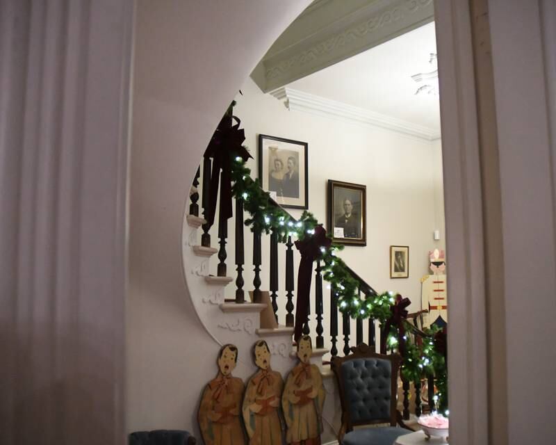 Historical photographs line the stair well of The Samuel Vial House that is the Historical society and museum in La Grange was one of four homes on display during the Holiday Sip and Sweet Tour event held on Sunday Dec. 17, 2023.