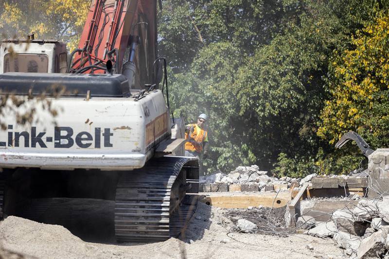 A worker directs an excavator Wednesday, Sept. 17, 2025, as the tower is slowly being chipped away. As of Friday, the bowl was largely gone, with the concrete supports still standing.