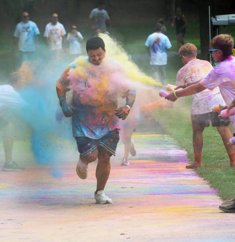 Philip Arellano of Dixon gets hit with a stream of yellow powder at the final color station at the Oregon Park District's color run on Tuesday, July 30, 2024. The annual event was held at Oregon Park West.