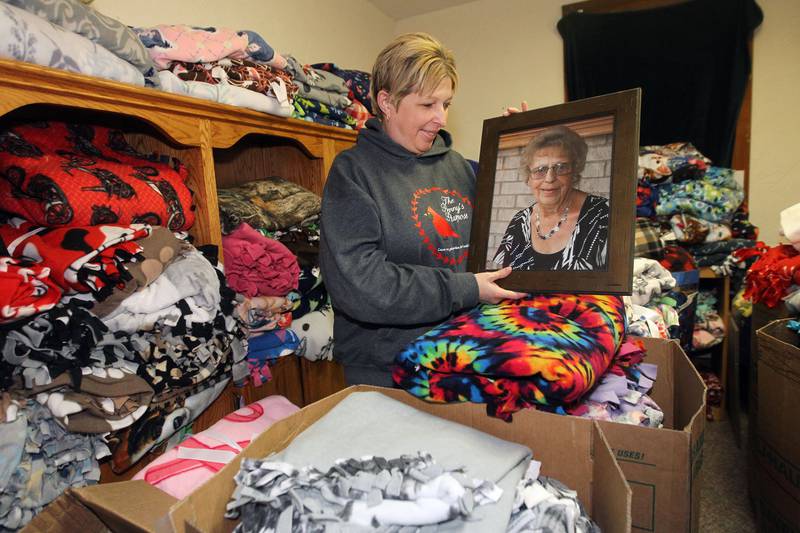 April Soulak-Andrews, of Antioch, president and founder, holds a photo of her mother, Penny, in the fleece room Dec. 18 during The Penny’s Purpose Annual Blanket Drive in Antioch. The blanket drive is in honor of April's mother, Penny, who died in 2019.