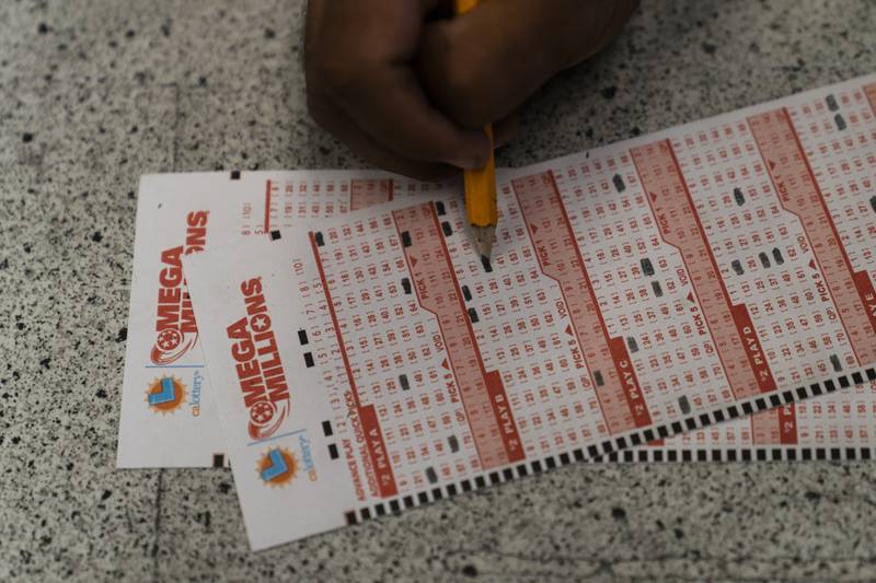 Prince Joseph Israel fills out Mega Millions playslips at Blue Bird Liquor in Hawthorne, Calif., Tuesday, July 26, 2022.  (AP Photo/Jae C. Hong)