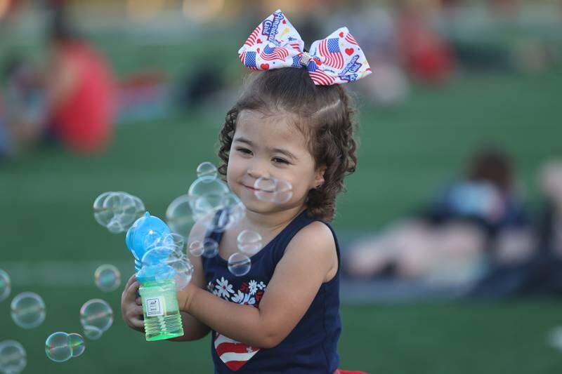 Celeste Caldera, three-years-old, plays with a bubble gun before the start of the fireworks at Joliet Memorial Stadium in on Thursday July 4, 2024.