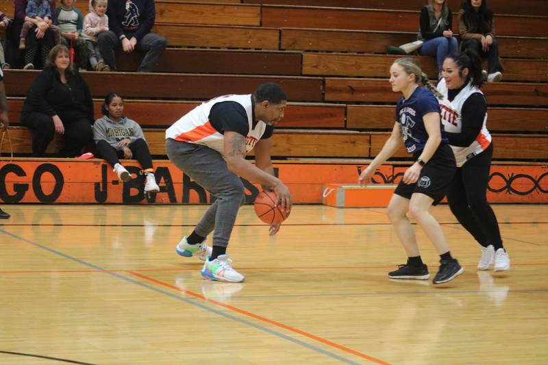 Darnell Coleman (left) dribbles around  Claudia Garcia (right) as she sets a screen on his defender, Savannah Long Dec. 4, 2023 during the annual Guns and Hoses Basketball Game put on at Huntley Middle School in DeKalb.