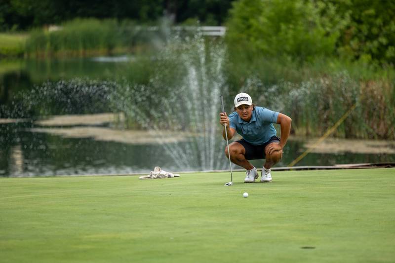 Jayden Nambo crouches to read green before putt at the 45th Richard J. Berry Memorial golf tournament on Sunday, July 13, 2025 at The Eastwood in Streator.