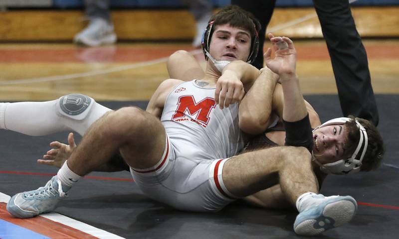Marian Central's Vance Williams tries to get out of the grasp of Joliet Catholic's Nolan Vogel in their 150-pound match during a triangle wrestling meet on Saturday Jan. 11, 2025, between Marian Central, Joliet Catholic, and Mt. Carmel at Marian Central HighSchool in Woodstock.