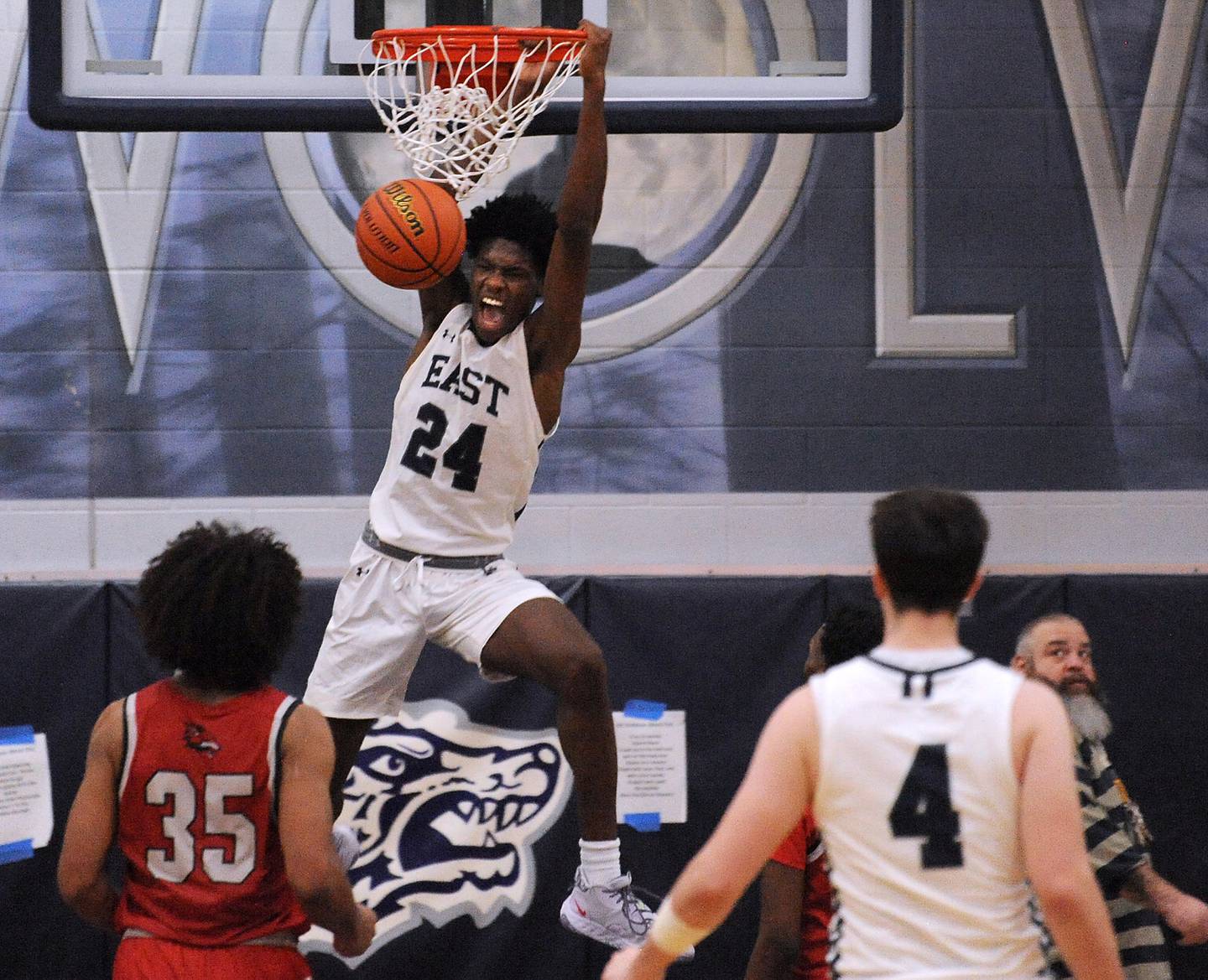 Oswego East's Mekhi Lowery goes high above the Yorkville defense for a slam during a boys’ varsity game at Oswego East High School on Tuesday, Dec. 6, 2022.