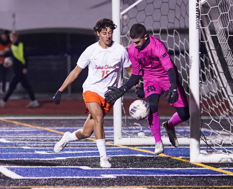 St. Charles East's Brandon Pinto (15) challenges New Trier's Thomas Terry (1) for the ball in front of the New Trier goal during the class 3A St. Charles North Boys Soccer Supersectional match at St. Charles North High School on Wednesday, Nov. 1, 2023.