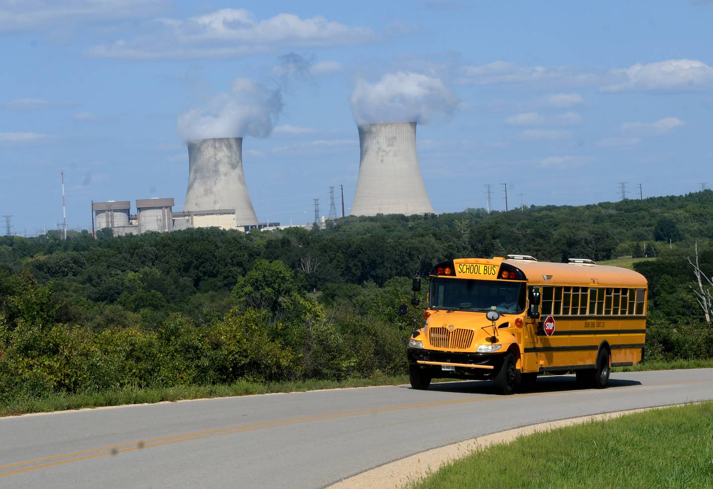 An Oregon school bus rounds a curve on N. Daysville Road with the Byron nuclear power plant in the background. The Byron School District, along with other taxing districts in Ogle County, would see a sharp decrease in revenues from their tax base if the plant were to be shuttered and its assessment value decreased.