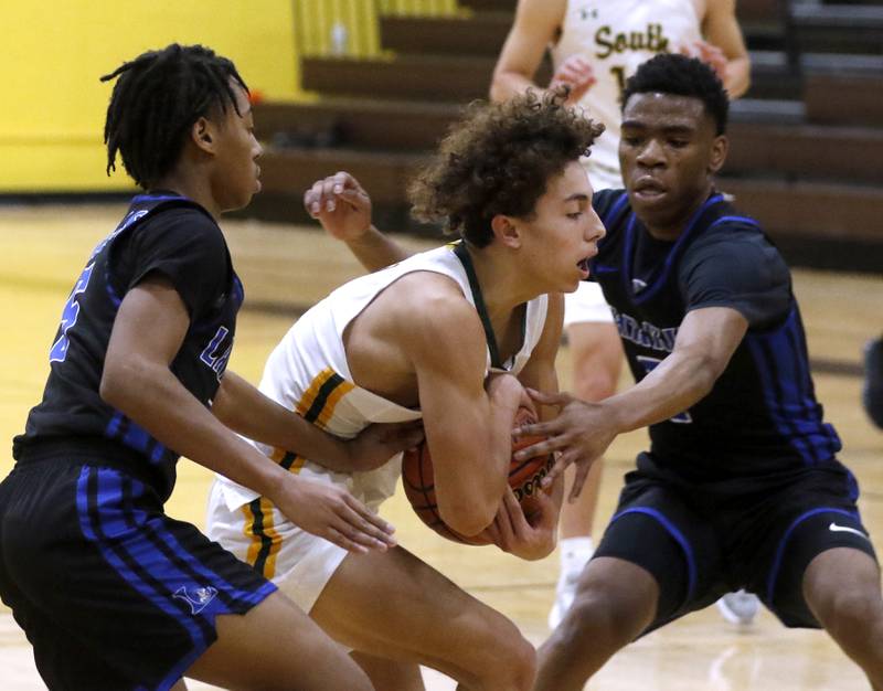 Crystal Lake South's Anthony Demirov protects he ball as he drive to drive to the basket between Larkin’s Damani Cannon and Jasavion Sowers during a Hinkle Holiday Classic basketball game Wednesday, Dec. 28, 2022, at Jacobs High School in Algonquin.