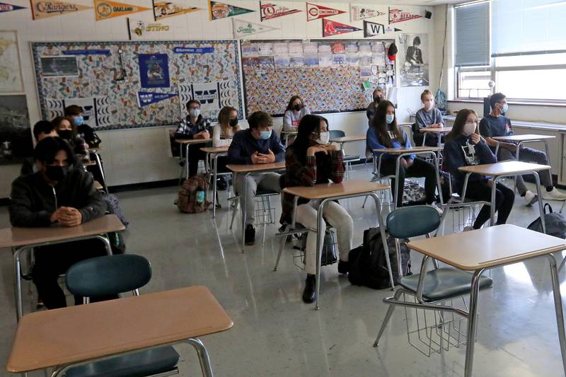 Students, spaced more than three feet apart, sit and watch a movie in geography class at Woodstock High School on Wednesday, May 12, 2021 in Woodstock.